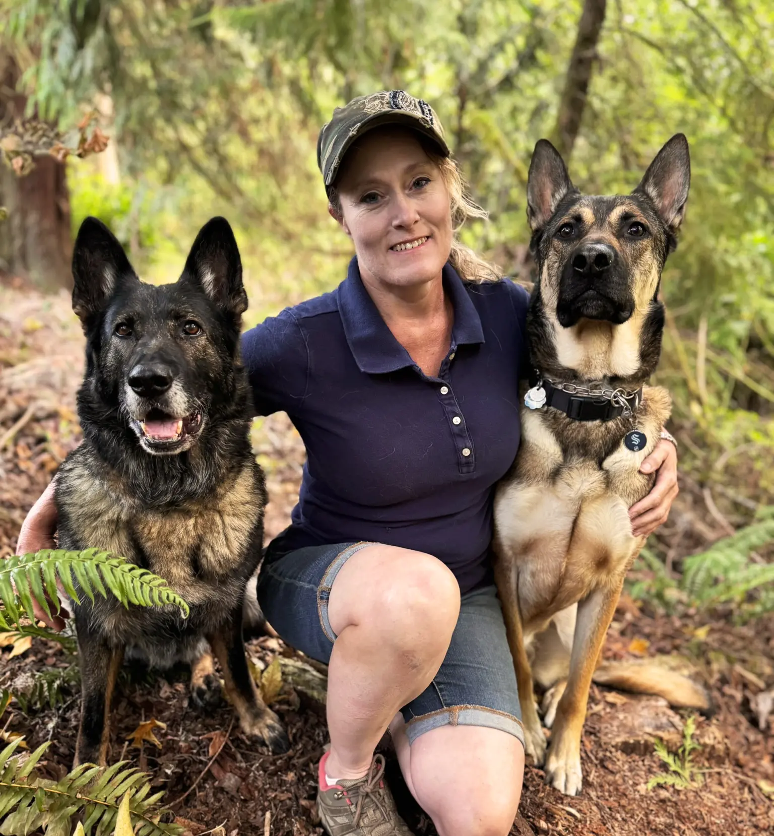 Woman sitting with two pet dogs during a training and bonding session